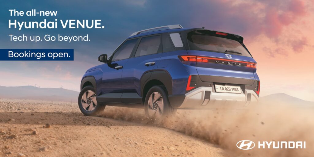 Rear three-quarter view of the all-new 2025 Hyundai Venue in blue, highlighting its new Rear Horizon LED Tail lamps and bold SUV design while driving on a dirt road.